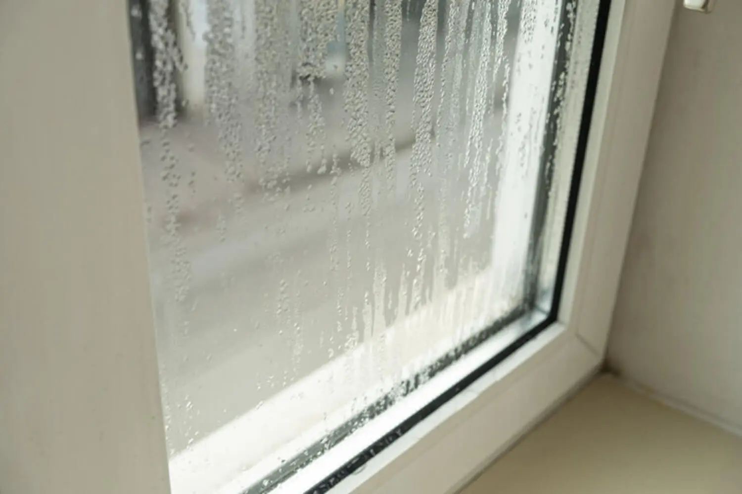Condensation forming on an exterior window surface, showing the kind of moisture buildup that prevents exterior paint from bonding correctly.