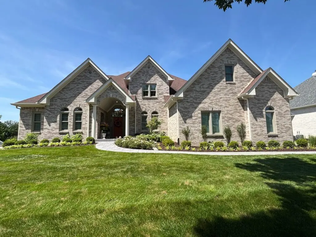 Exterior painting on a large stone and brick two-story home in Brownsburg, IN
