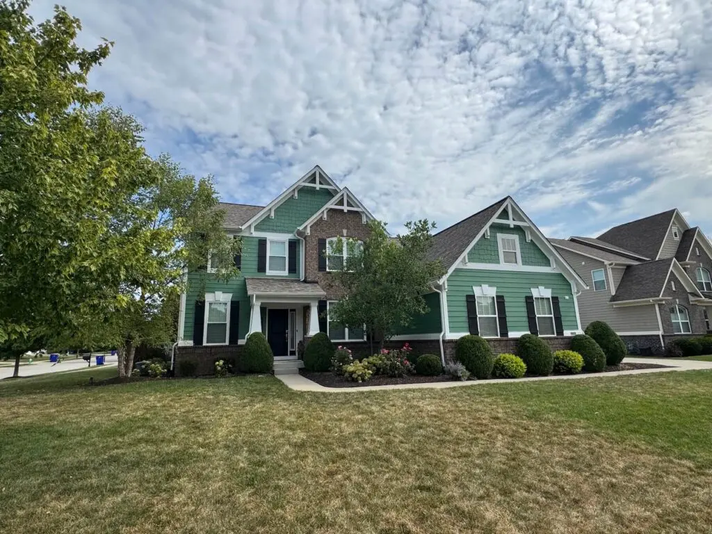 Two-story home with freshly painted green exterior accents in Brownsburg, IN