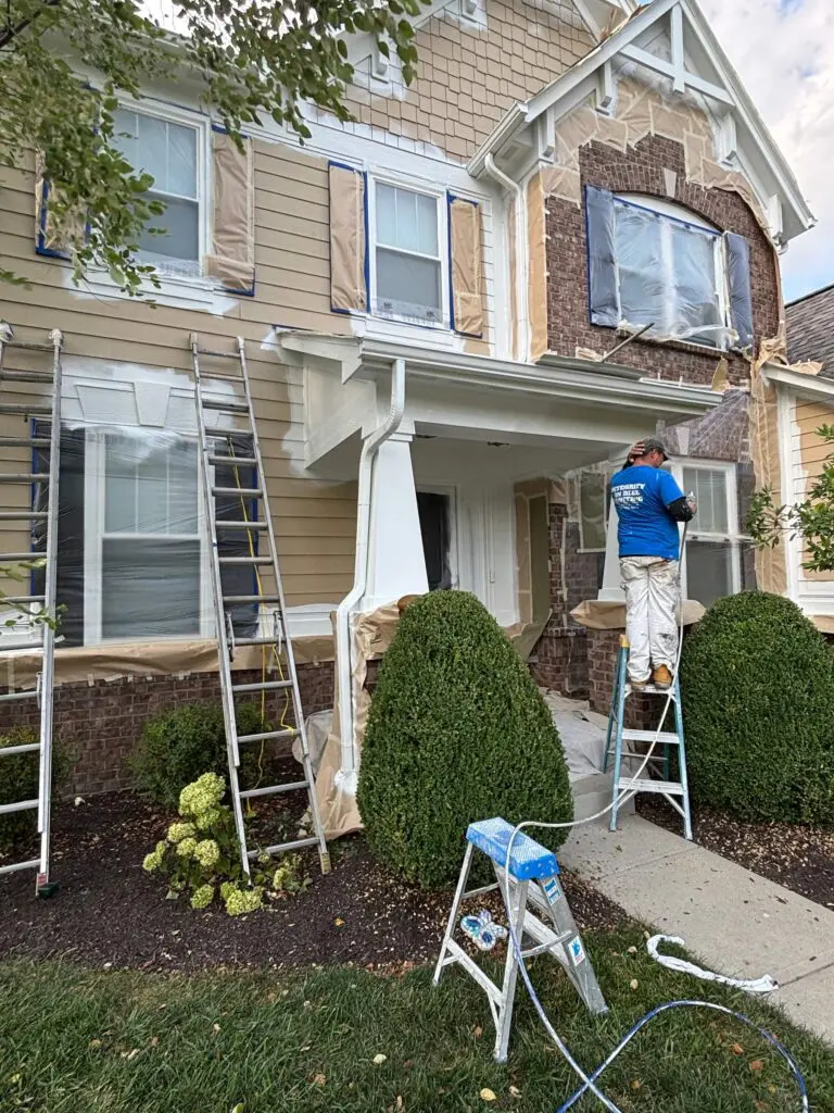 Integrity in Blue painter on a ladder completing exterior painting on a Brownsburg, IN home