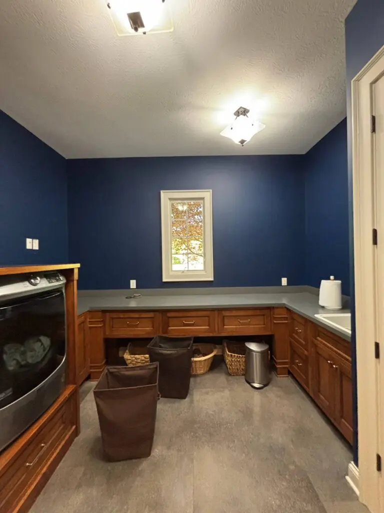 Kitchen with dark blue walls and wood cabinetry after interior painting in Brownsburg, IN